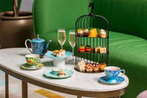 a table with cups and plates of food and drinks at Naumi Hotel Wellington in Wellington