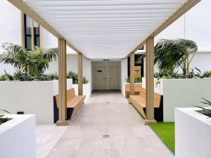 a hallway in a building with benches and plants at Chermside deluxe 3 bedroom brand new apartment in Brisbane