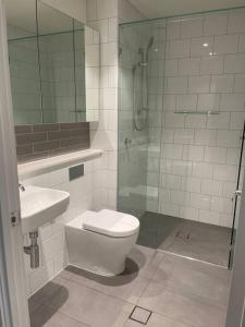 La salle de bains est pourvue d'une douche, de toilettes et d'un lavabo. dans l'établissement Chermside deluxe 3 bedroom brand new apartment, à Brisbane