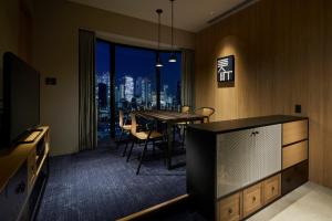 a dining room with a table and a view of the city at Hundred Stay Tokyo Shinjuku in Tokyo