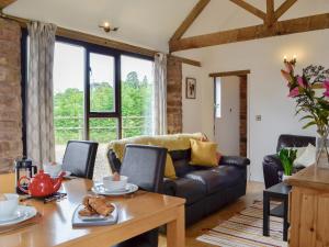 a living room with a couch and a table at Court Park Barn in Tidenham