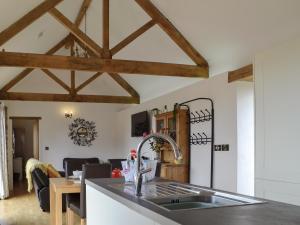 a kitchen with a sink and a living room at Court Park Barn in Tidenham