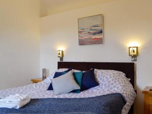 a bedroom with a bed with blue pillows at Court Park Barn in Tidenham