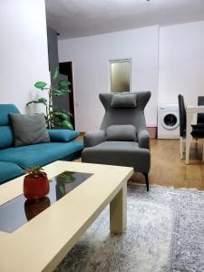 sala de estar con sofá y silla en Roni Apartment, en Durrës