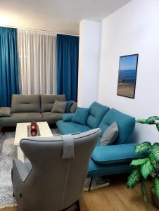 sala de estar con sofá azul y mesa en Roni Apartment, en Durrës