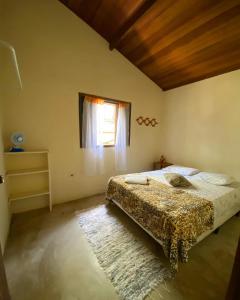 1 dormitorio con cama y ventana en Suítes Canto do Nema, en Ilhabela