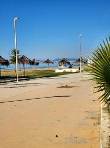 een strand met rieten parasols en de oceaan bij Roni Apartment in Durrës