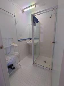 een badkamer met een douche en een wastafel bij Top of the Lake Holiday Units in Merimbula