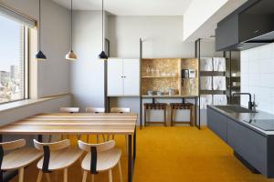 a kitchen with a wooden table and chairs at Hundred Stay Tokyo Shinjuku in Tokyo