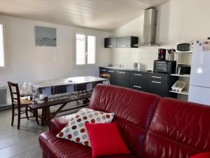 Il comprend un salon avec un canapé rouge et une cuisine. dans l'établissement Maison Bretignolles-sur-Mer, 3 pièces, 4 personnes - FR-1-231-63, à Bretignolles-sur-Mer
