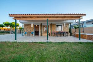 een paviljoen met een tafel en stoelen op een patio bij Omega Estate Resorts in Kypseli