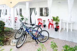 duas bicicletas estacionadas fora de uma casa com cadeiras vermelhas em Hermosa Suites #2 in the heart of PUNTA CANA em Punta Cana