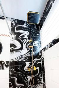 a bathroom with a black and white patterned wall at Hermosa Suites #2 in the heart of PUNTA CANA in Punta Cana