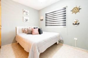 蓬塔卡納的住宿－Hermosa Suites #2 in the heart of PUNTA CANA，一间卧室配有带粉红色枕头的床。