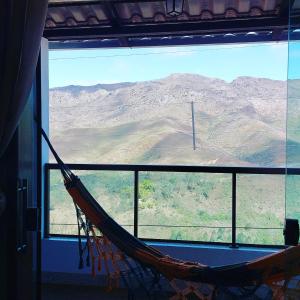 a hammock in a room with a view of a mountain at Casa Nova em Ouro Preto e Mariana in Ouro Preto