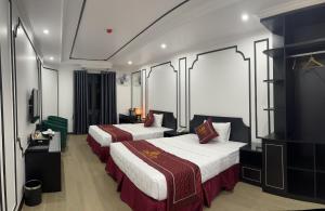 um quarto de hotel com duas camas e uma televisão em Rosy Hotel em Hanói