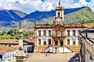 an old building with a clock tower in a town at Casa Nova em Ouro Preto e Mariana in Ouro Preto