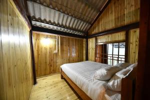 a bedroom with a bed in a wooden room at Sapa Fantasea Homestay in Sapa
