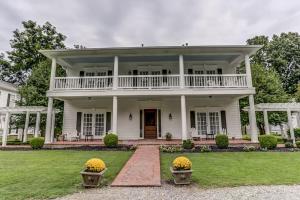 a white house with a porch and a balcony at Bonne Terre Inn Magnolia Room 