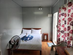 a bedroom with a bed with a fan and a window at La Bella Swiss Inn in San Vicente