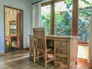 una scrivania in legno con sedia e specchio di Cozy Wayan Sueta's Garden Villa 2 ad Ubud