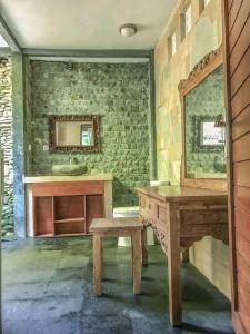bagno con tavolo in legno e specchio di Cozy Wayan Sueta's Garden Villa 2 ad Ubud