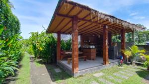 een houten prieel met een tafel in een tuin bij Morning Bali Bungalow in Canggu