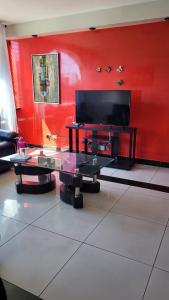 a living room with red walls and a flat screen tv at Apartamento 906 zona 9 in Guatemala