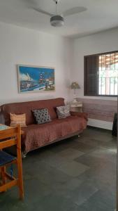 a living room with a red couch and a window at Casa de Praia 4qtos em Saquarema! in Saquarema