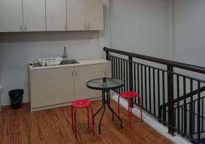 a kitchen with two red stools and a table and a counter at 158 Guest House Syariah RedPartner in Bandung +18 photos