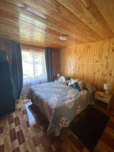 1 dormitorio con 1 cama en una habitación de madera en Angel Cabaña, en Villarrica