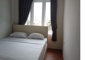 158 Guest House Mitra RedDoorz في باندونغ: سرير مع وسادتين في غرفة نوم مع نافذة
