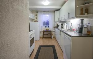 cocina con electrodomésticos blancos y encimera en Beautiful Home In Stokmarknes With House A Panoramic View, en Stokmarknes