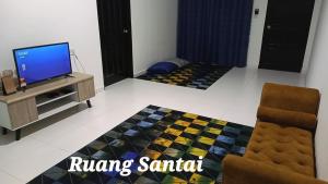 sala de estar con TV y sofá en Cikgu Huda Homestay Bajet, en Seri Manjung