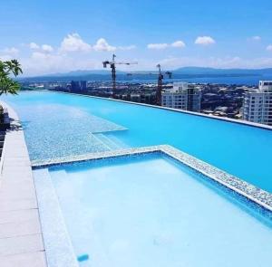 a large swimming pool on top of a building at Homey Comfy CondoTel - AEON Towers Davao in Davao City