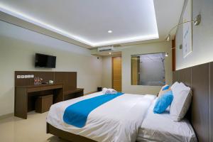 Tempat tidur dalam kamar di Sans Hotel Rumah Kita Daan Mogot by RedDoorz