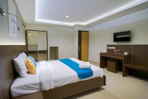 En eller flere senger på et rom på Sans Hotel Rumah Kita Daan Mogot by RedDoorz