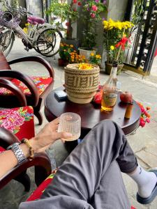 a person sitting on a chair next to a table at Bui Family Homestay in Hoi An