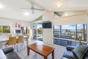 a living room with a view of the ocean at Reflections Bonny Hills - Holiday Park in Lake Cathie