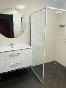 Un baño con ducha, lavabo y espejo. en Dreamtime Hostel, en Cairns 34 fotos más