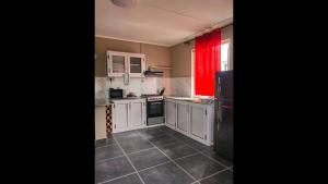 a kitchen with white cabinets and a black refrigerator at Residence Devika2 Trou aux Biches in Trou aux Biches