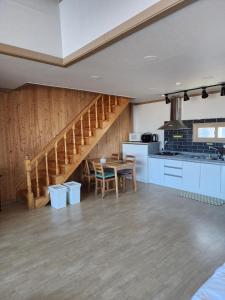 a kitchen and dining room with a staircase in a house at Gyeongpodae Darakbang in Gangneung