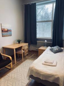 a bedroom with a bed and a table and a window at Easy Huoneistot Vierumäki in Härkälä