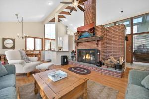 a living room with a brick fireplace and a table at Pocono Pines, Lake Naomi 4 bedrooms, 2 full bath in Pocono Pines