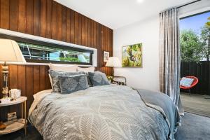 um quarto com uma cama e uma grande janela em Newton Heights em Akaroa