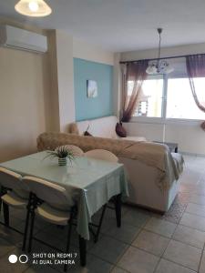 a bedroom with a bed and a table and a couch at "By The Sea" Family apartments in Paralia Dionysiou