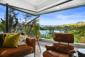 uma sala de estar com um sofá e uma grande janela em Newton Heights em Akaroa