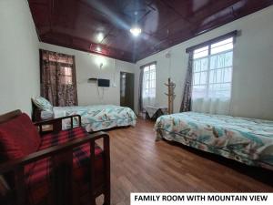 een familiekamer met 2 bedden en een bank bij Odyssey's Pateng Homestay, Cherrapunji in Cherrapunji