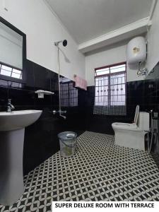 a black and white bathroom with a sink and a toilet at Odyssey's Pateng Homestay, Cherrapunji in Cherrapunji