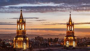 two towers of a building with a city in the background at Crismar Experience By Xima Hotels in Arequipa